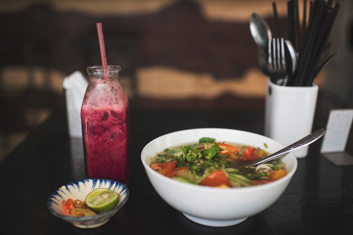 A bowl of Pho and a berry smoothie in a restaurant in Ho Chi Minh City