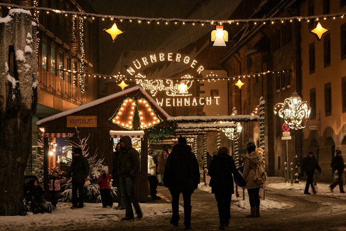 People walking through Nuremberg's Christmas market at night time