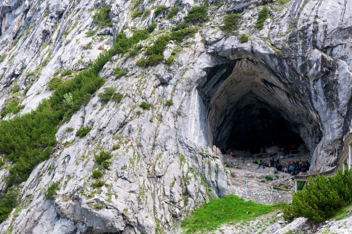 Visitors gathering in the mouth of Eisriesenwelt Caves in Austria, near the Danube