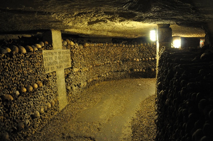 Human skulls and bones lining a corridor in the Paris catacombs