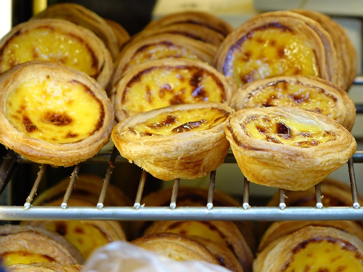 Portuguese pastel de nata custard tarts on a rack in a bakery