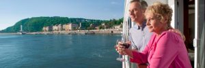 A couple enjoying a glass of wine on the veranda of their river cruise ship